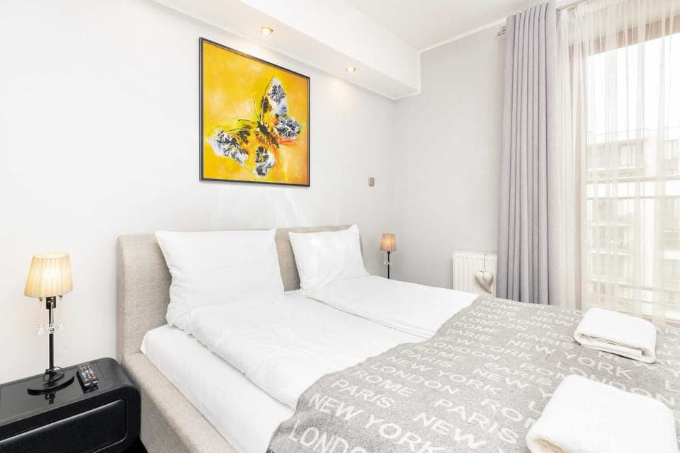 Cozy bedroom with a comfortable bed, night lamp, and modern decor.
