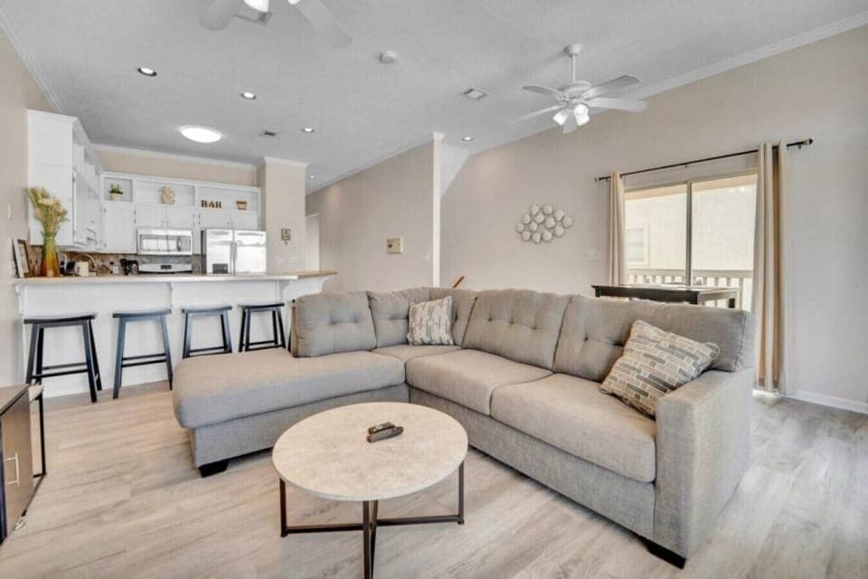 Gather, relax, and unwind in this open living space with bar seating and cozy vibes.