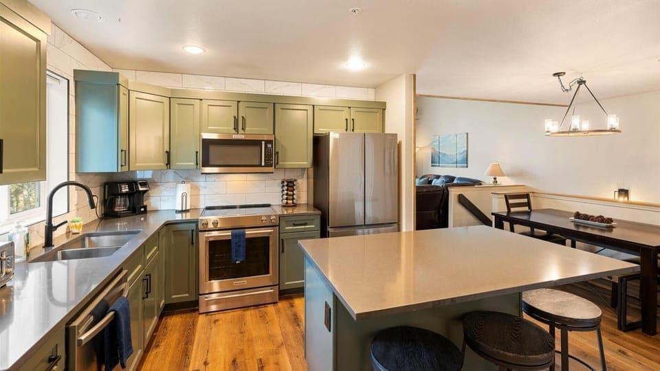 Newly remodeled open concept fully stocked kitchen with breakfast bar seating for 4 and access to deck with hot tub, outdoor dining space, and BBQ grill.