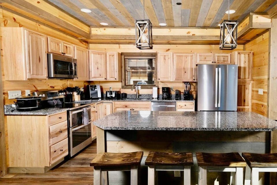 The fully equipped kitchen has stainless appliances, granite countertops and a large island.