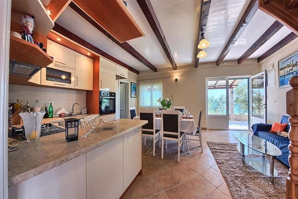 Fully equipped kitchen with dining table and couch in family vacation villa in Ciovo in Trogir with wi-fi