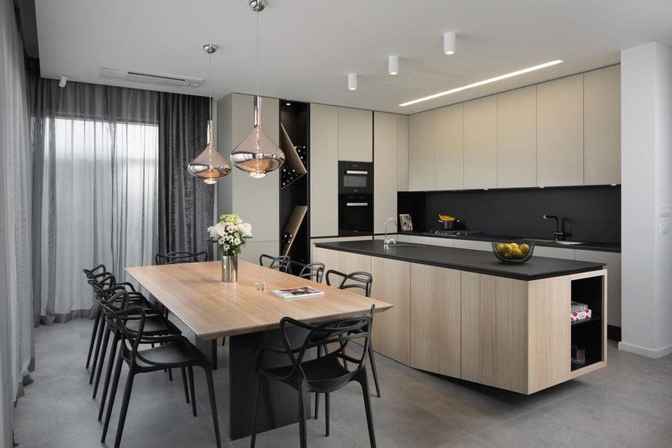 The interior of a luxury villa with a kitchen, a kitchen island and a dining table with chairs in a luxury villa for family vacation Pula Deluxe in Pula