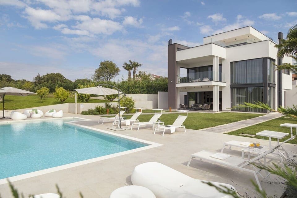 View of Croatia luxury villa Deluxe Pula with private pool and outdoor terrace with sun loungers and parasol