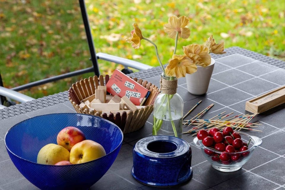 A tray on a table with fresh fruits, bread, and a cup of tea, styled for a cozy breakfast setting.