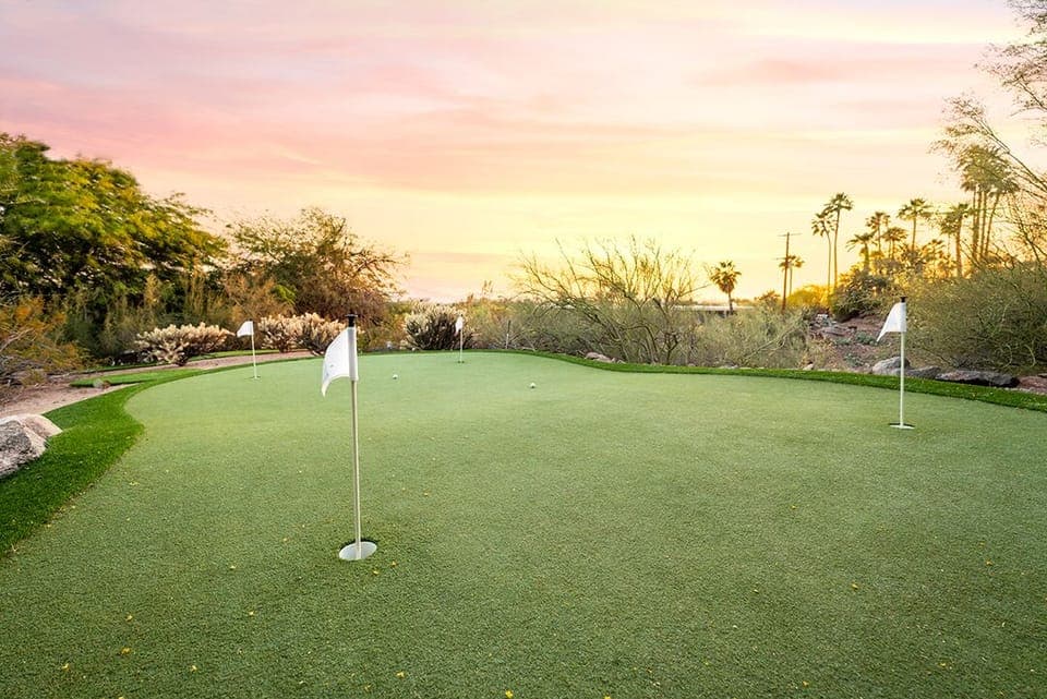 Discover the perfect putting paradise: a spacious four-hole putting green embraced by lush landscaping.