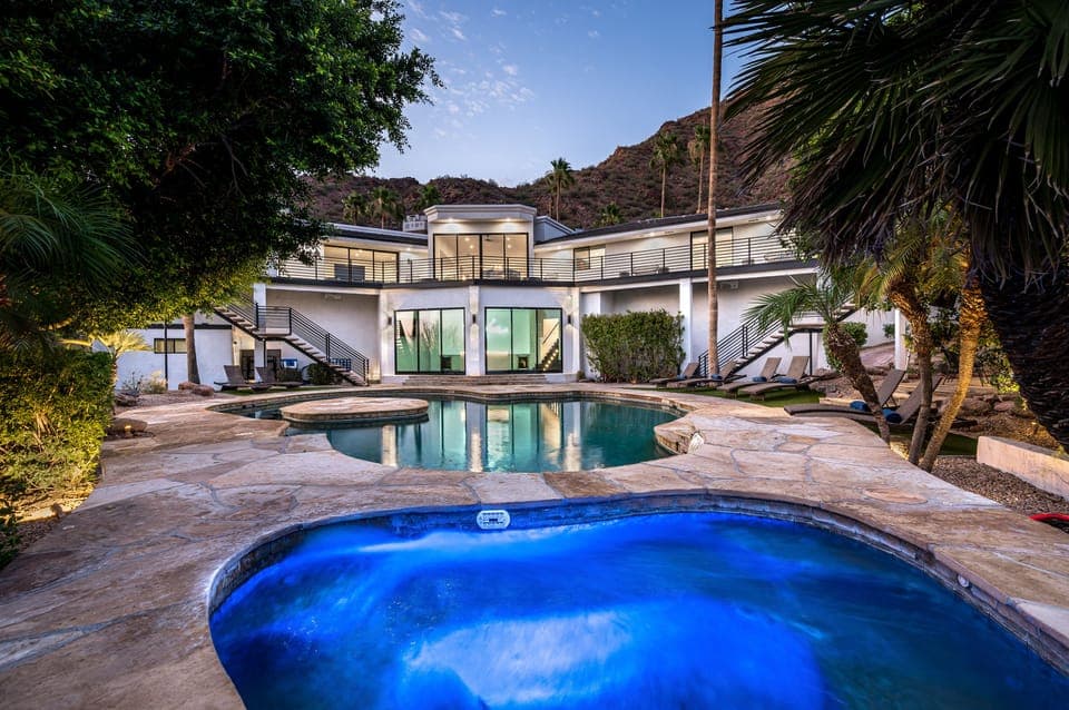 Capture the epitome of luxury living with the spa and pool glistening in the foreground, while the elegant 2-story home stands in the background.