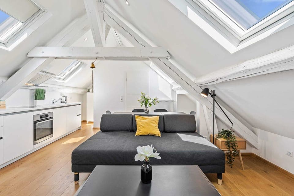 Cozy up in our chic loft, where comfort meets style under sunlit beams.