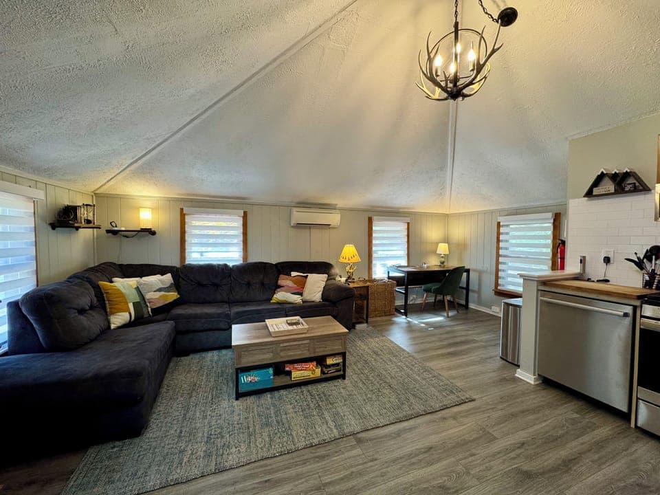 Cozy vaulted lounge with games, sleek kitchenette, and a sunny work nook