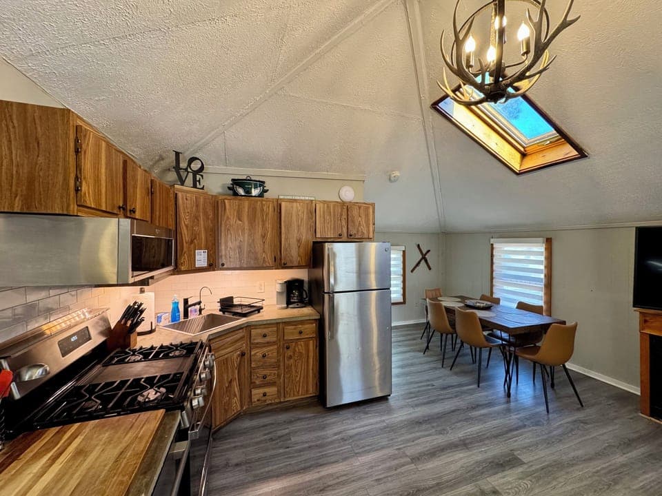 Bright vaulted kitchen with skylight, gas range, and dining for six.