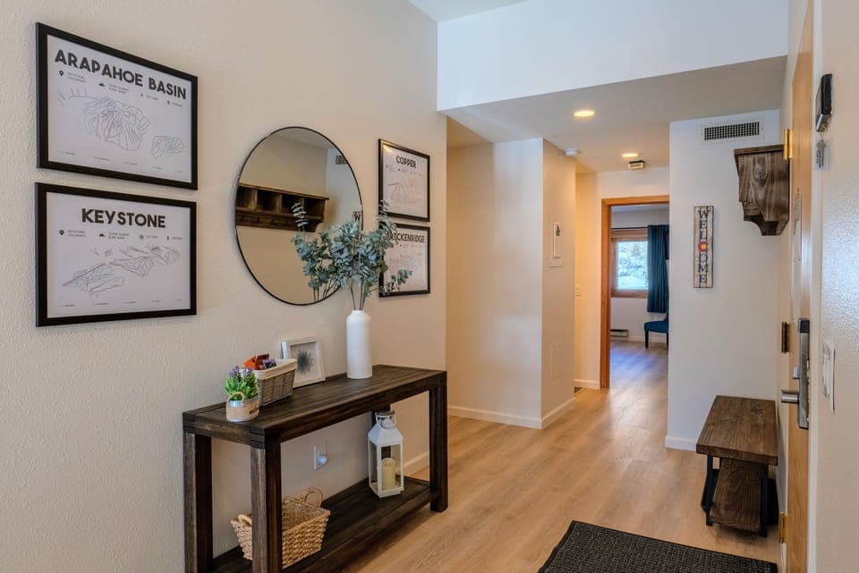 Hallway entrance with mirror, ski maps, coat hangers and a bench