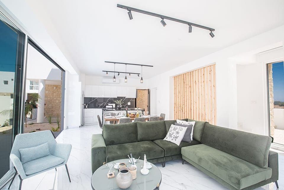 Living room with comfortable seating area and patio doors leading to the garden