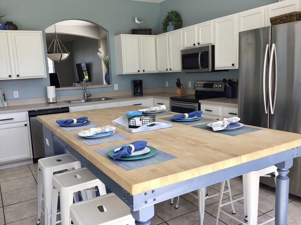 Eat-in kitchen with updated appliances and large sliding doors to the pool.