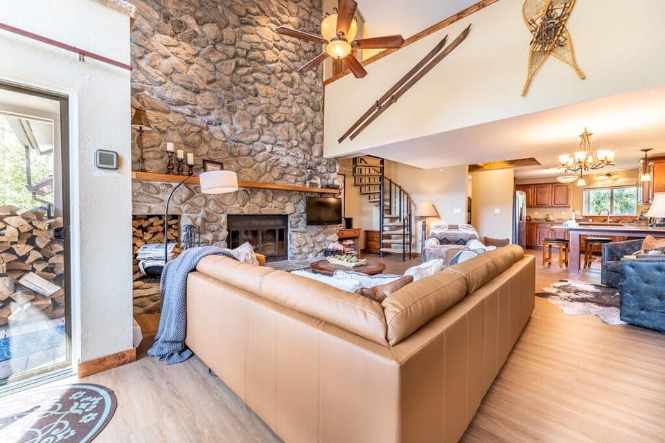 Spacious living area featuring large wood burning fireplace, ample seating and sweeping mountain views.