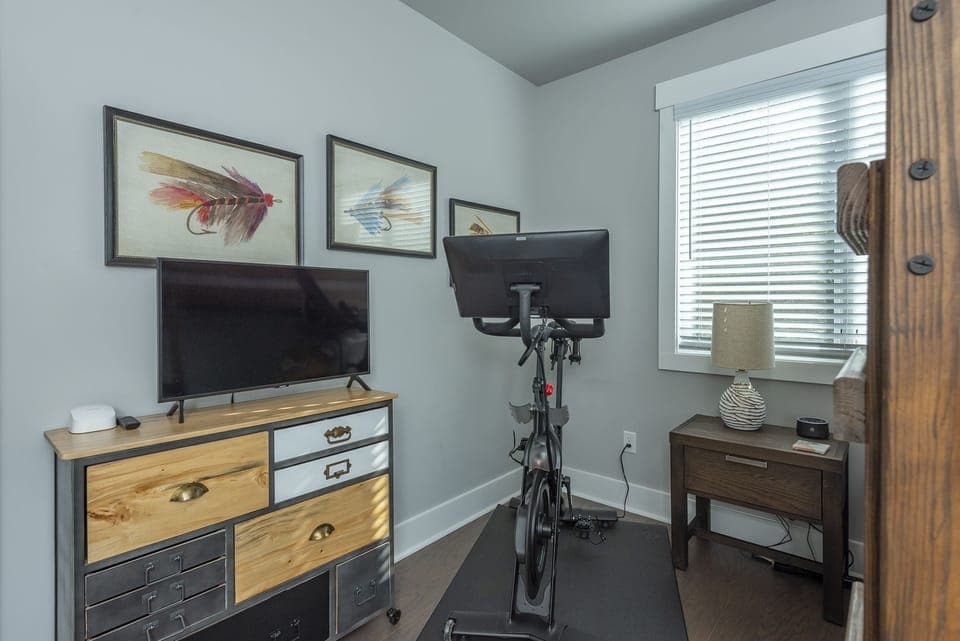 Upper-level bedroom with Full-size bunk bed & Peloton bike.
