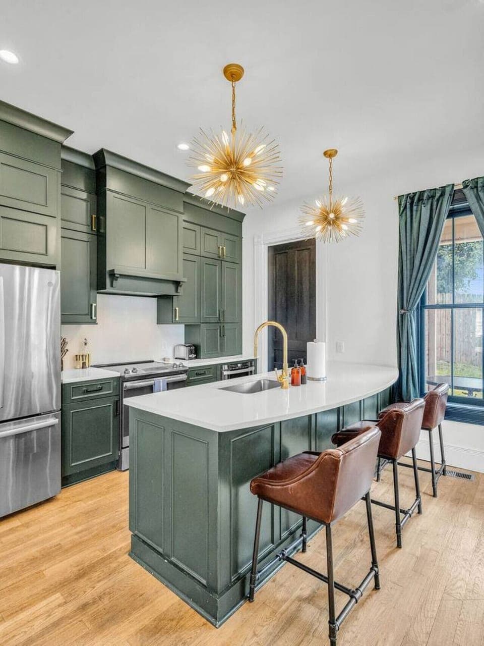Kitchen Oasis: Stylish green cabinetry and golden accents invite culinary adventures in comfort!