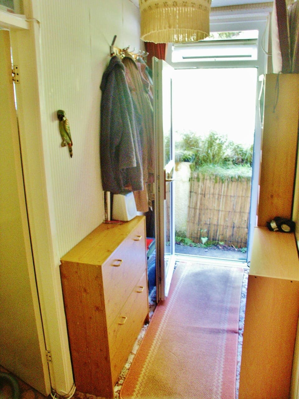 Hallway looking outside. Bathroom door on left