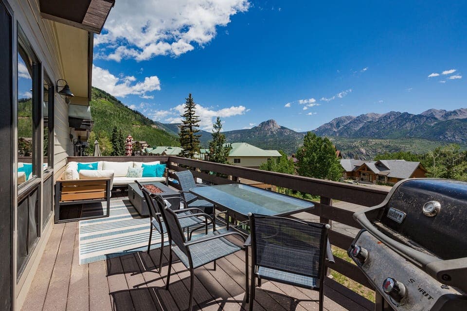 Huge deck with couch, gas fire put, dining table and gas grill