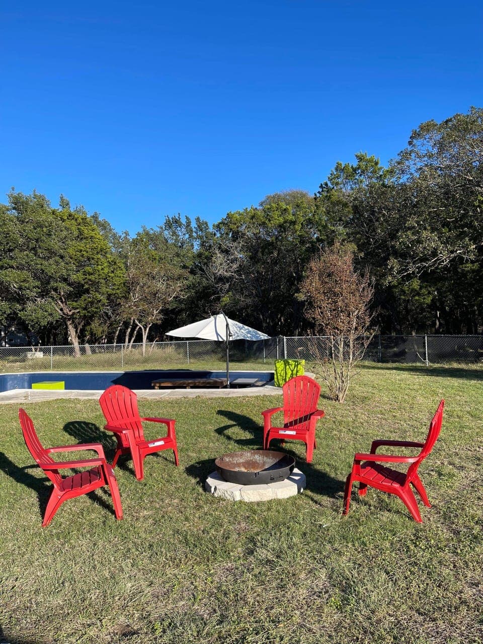 Fire pit in the backyard, next to the in-ground deck and porch