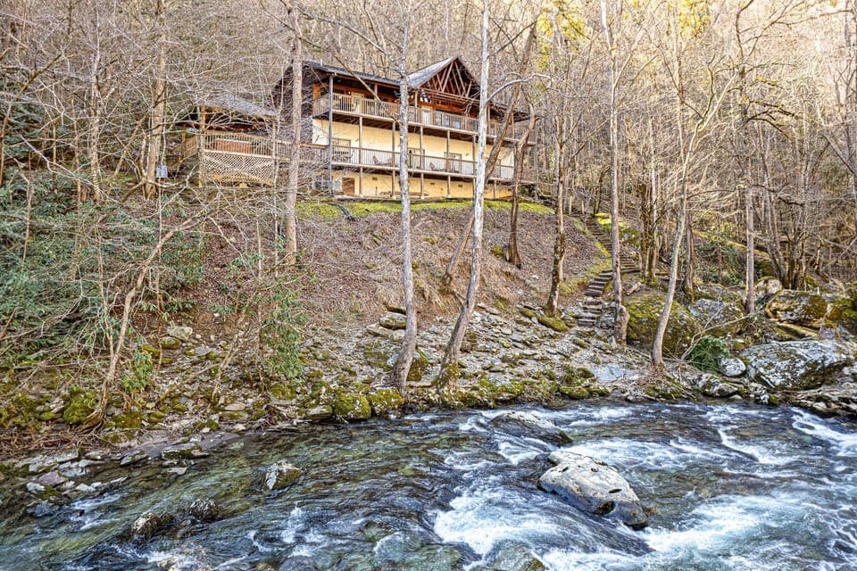 Secluded river view of the lodge. The decks run the width of the house.Check out the backyard! Fishing. Explore the river bank. Sit & watch the water.
