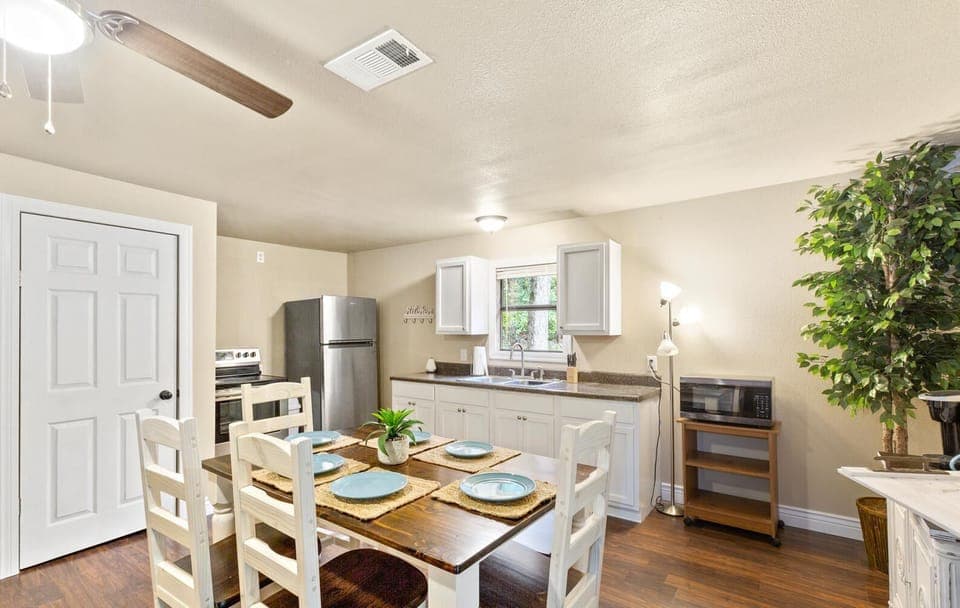 Kitchen with table for six, microwave and Keurig. 