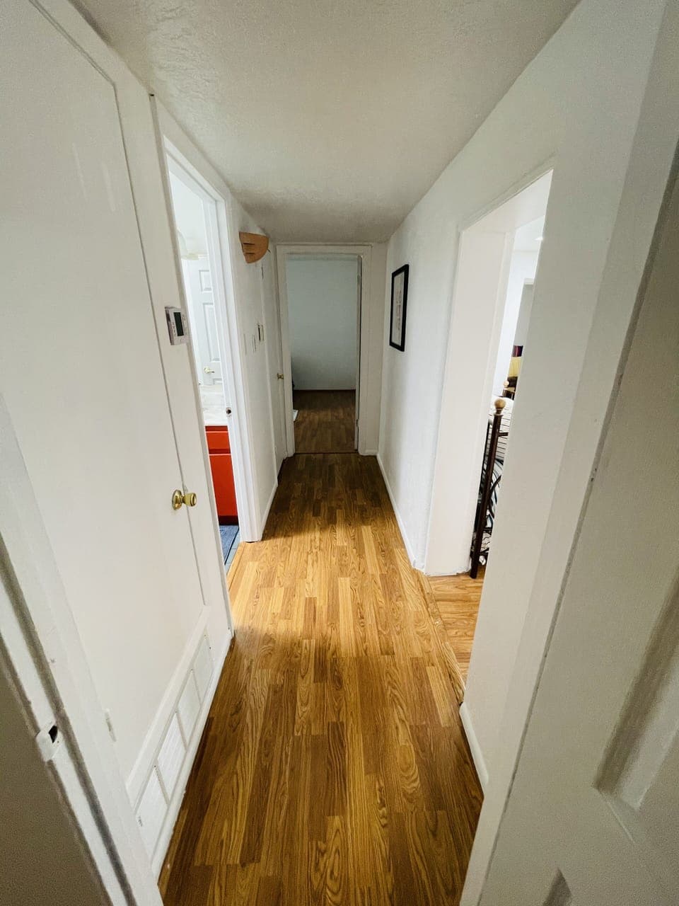 View of the hallway from one bedroom to other with bathroom in the middle.