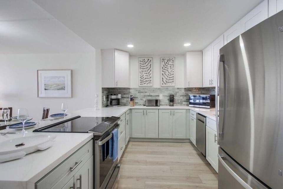 Modern kitchen is fully equipped with new stainless steel appliances including an electric stovetop and dual Keurig/standard coffee maker