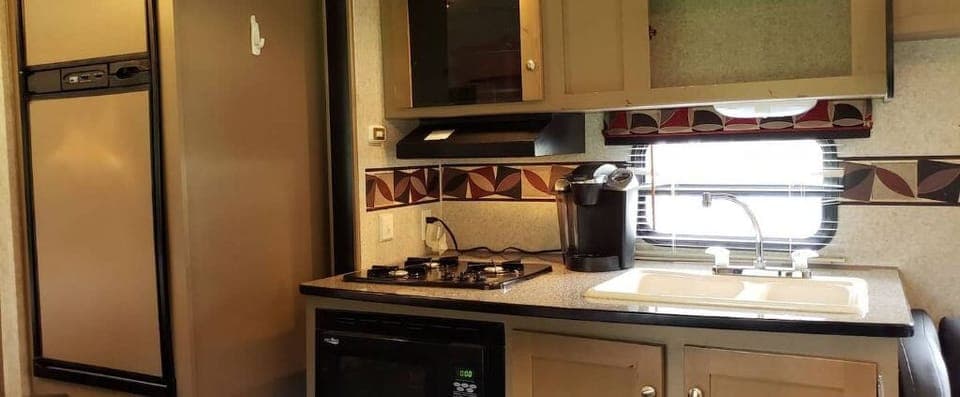 The kitchen has sink, stovetop, microwave, toaster, and Keurig coffee maker 