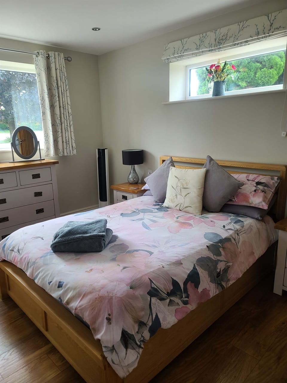 Cosy double bed with chest of drawers, wardrobe, full length mirror, portable fan, bedside tables and lamps, dimmer switch for spotlights.
