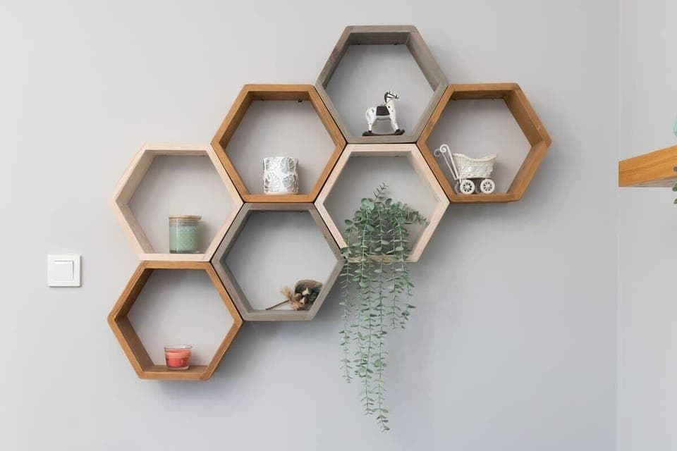 Hexagonal wall shelves featuring small plants, books, and decorative items, adding personality to the space.
