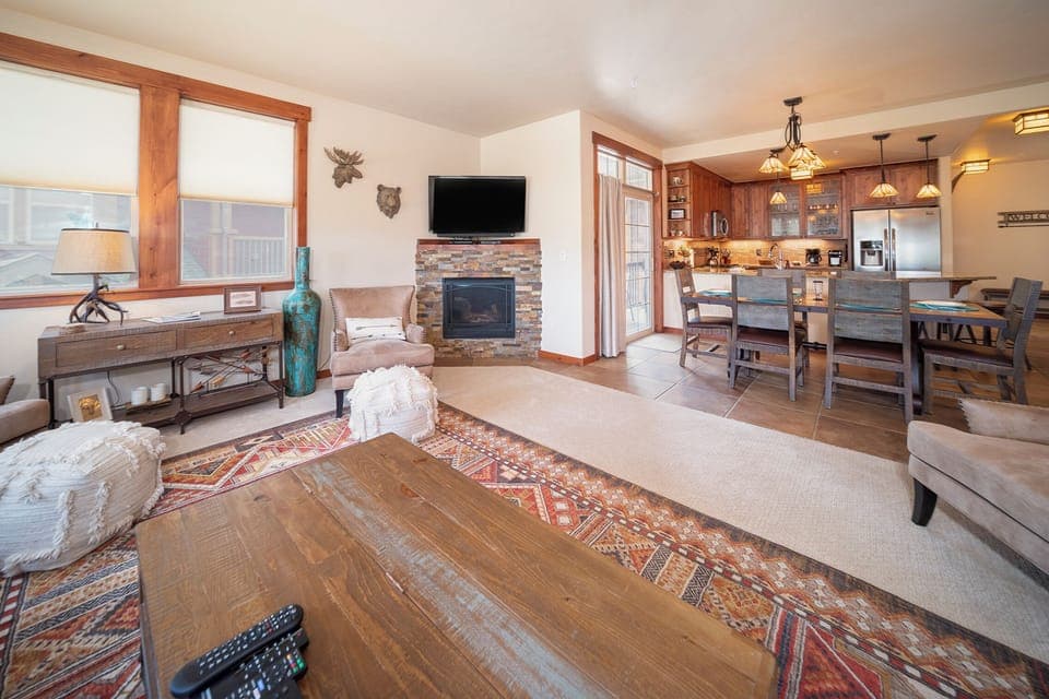 Unwind in your spacious open-concept retreat with a stone fireplace, fully equipped kitchen, and cozy seating perfect for memorable evenings.