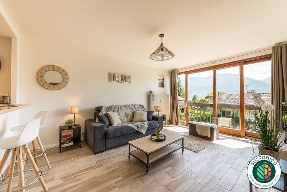 Living room with sofa bed, bay window with lake and mountain views