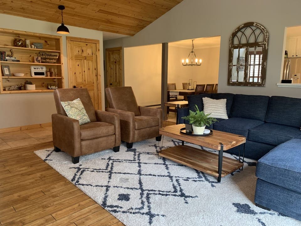 Spacious living room with vaulted ceilings,  cozy furniture, fireplace, and view