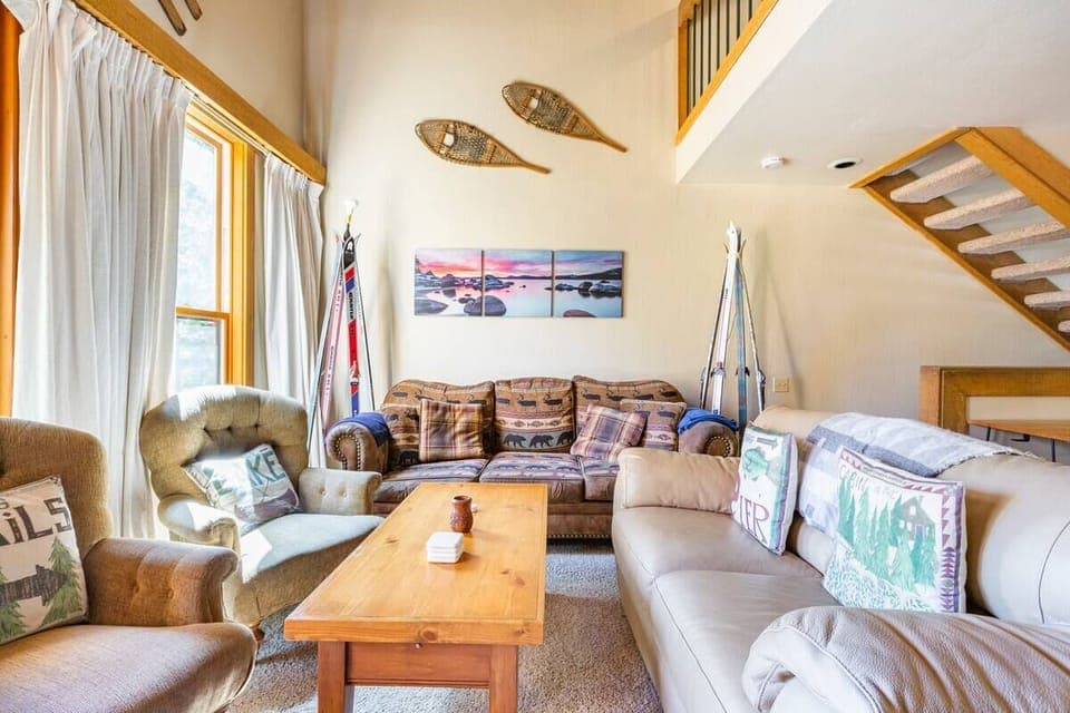 Living room with couches, chairs, coffee table for games and food. 