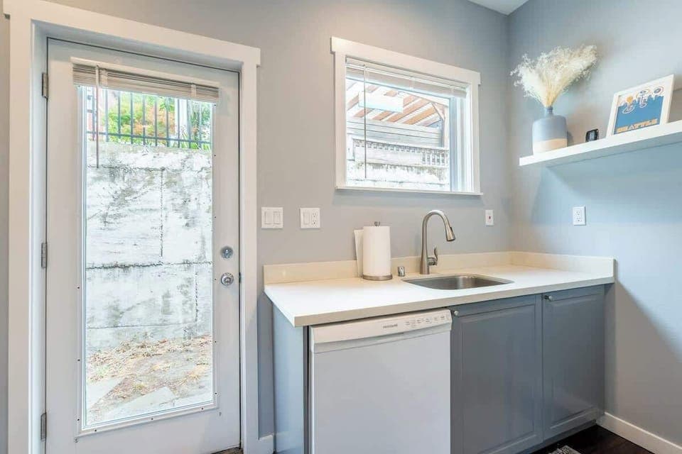 Well-lit kitchenette with essentials and a convenient patio door.