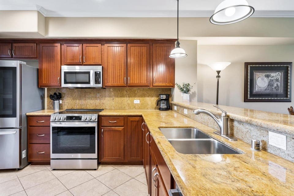 - Spacious kitchen with granite countertops, double sink, and full stainless steel appliances - Rich wood cabinetry and recessed lighting offer warmth and elegance - Fully equipped for cooking meals, prepping snacks, or sipping morning coffee