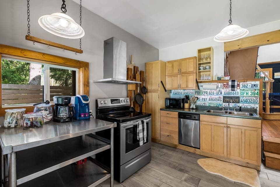 Full-sized kitchen at the back of the house with stainless steel appliances including a dishwasher