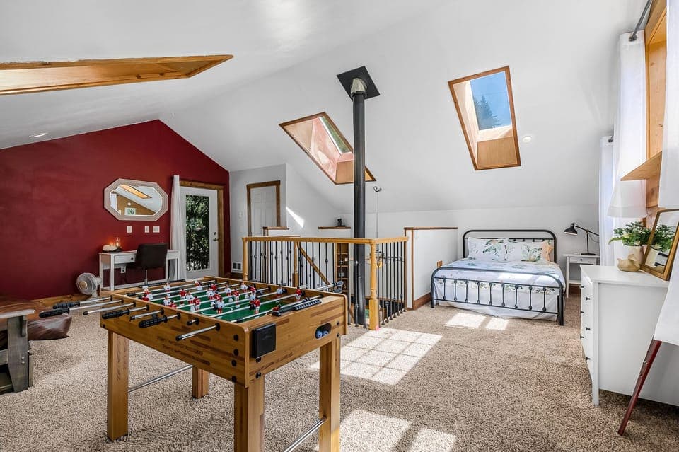 Foosball table and a Queen sized bed in the OPEN loft, no door for privacy here! The door in the back of this photo leads to the upstairs half bath