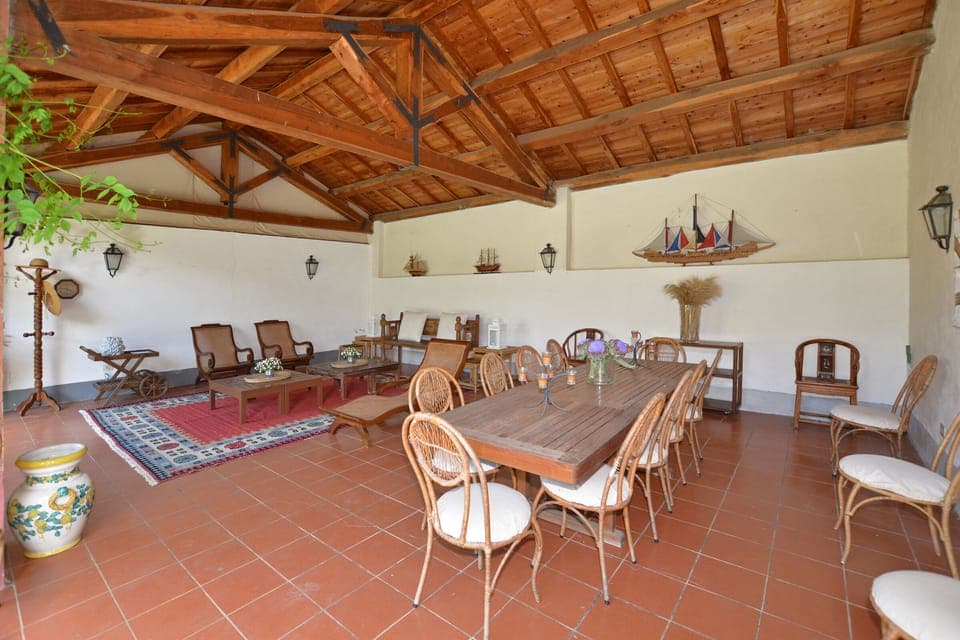 The equipped portico close to the pool with dining area and external living