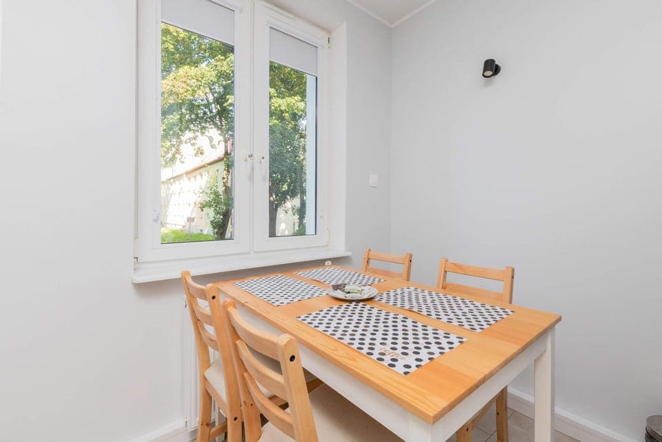 A modern dining area with wooden chairs and a table, perfect for small gatherings.
