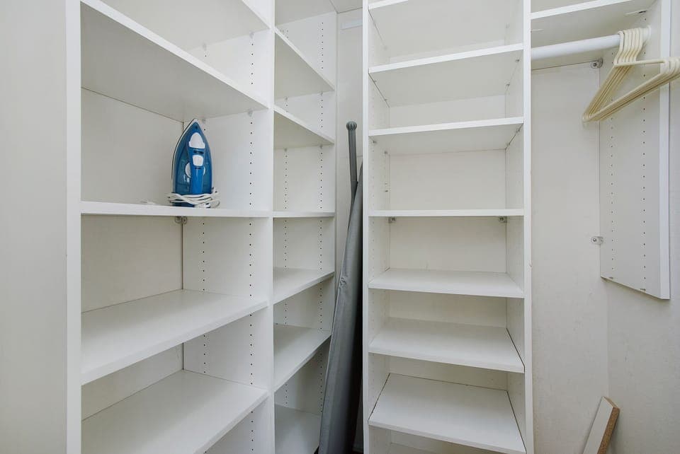 Large walk-in closet in 2nd bedroom with built-in shelving system.