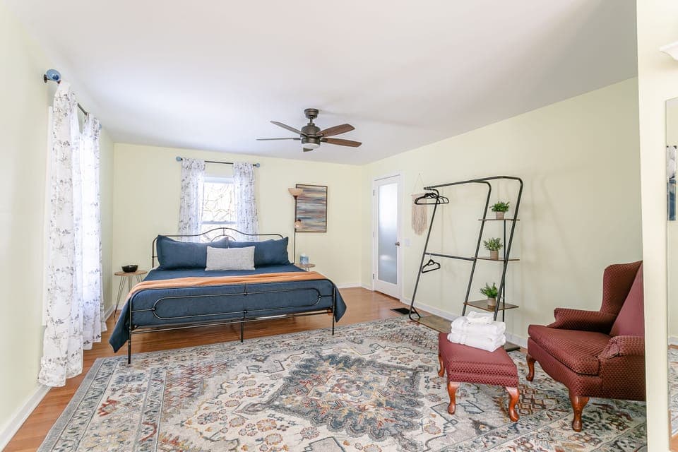 Get a good night's sleep in the primary bedroom, featuring a king size bed, overhead fan, hanging wardrobe and dedicated workspace.