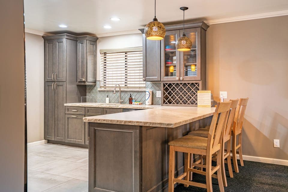 Kitchen's barstool seating with pendant lighting.