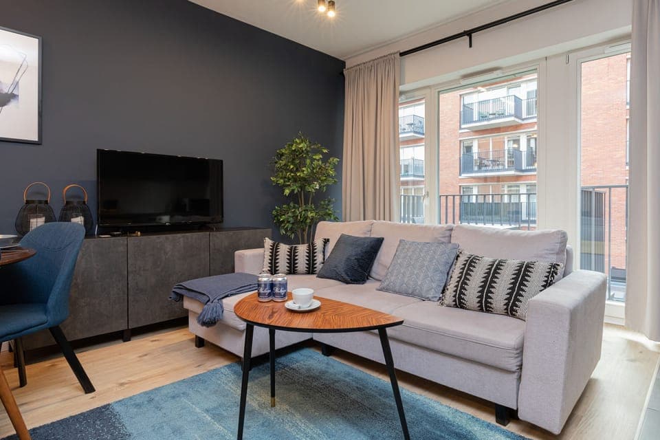 The living room features a sleek coffee table and a flat-screen television.