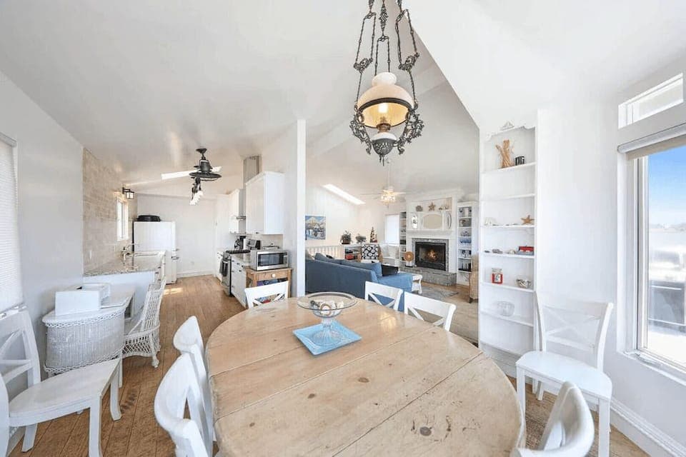 View from the dining area looking back into the kitchen and living room. Beyond the living room is the hallway which leads to bedrooms/bathrooms.
                