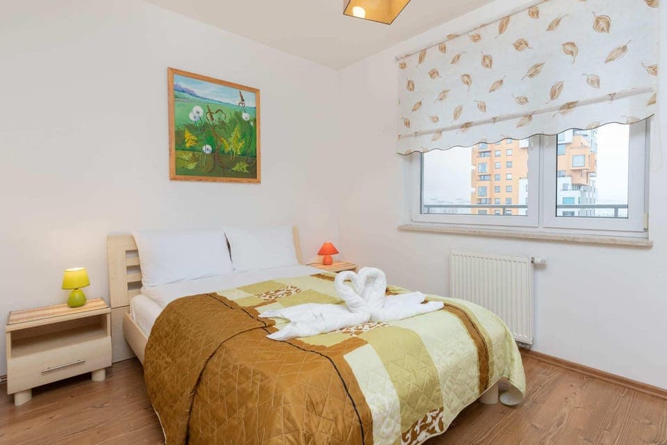 A cozy bedroom with a large bed, soft lighting, and colorful decor for a relaxing stay.
