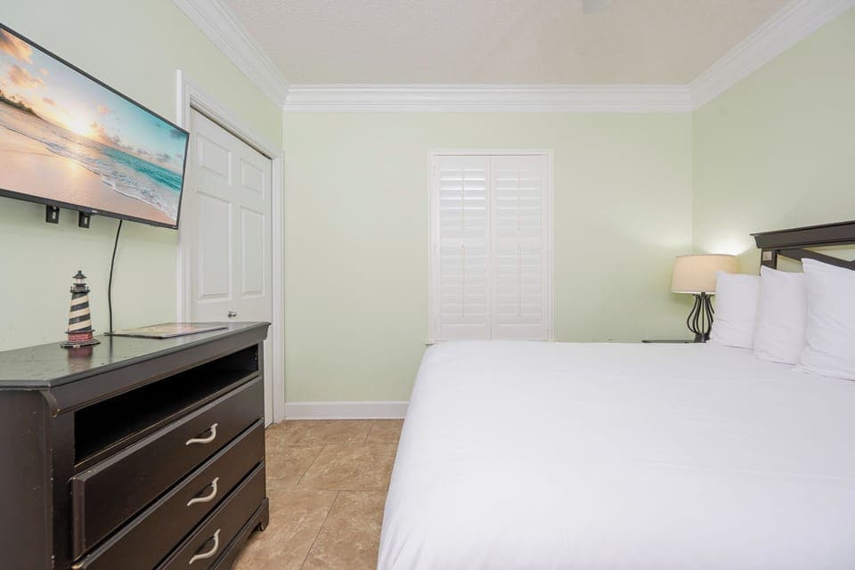 Unwind in this guest bedroom featuring a queen bed, soft linens, and a TV for your entertainment