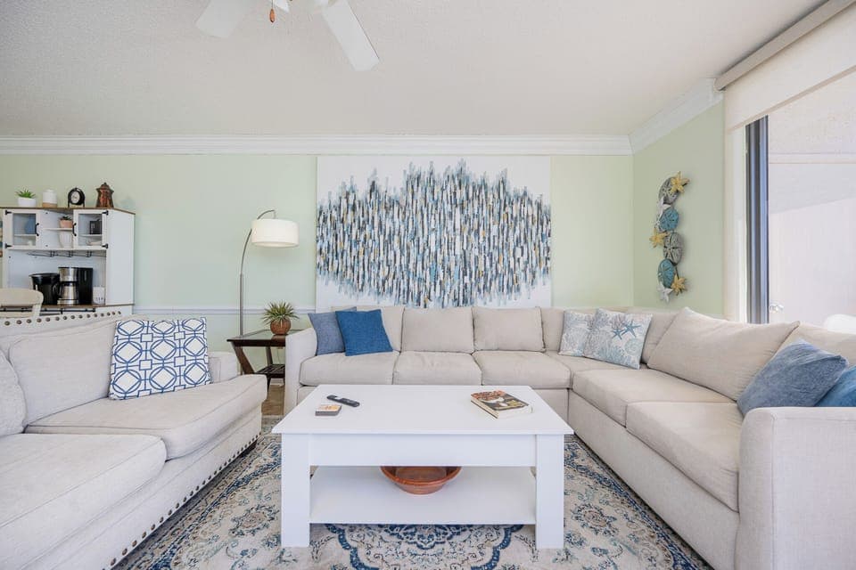 Unwind on the spacious sectional sofa, surrounded by coastal decor and inviting natural balcony light