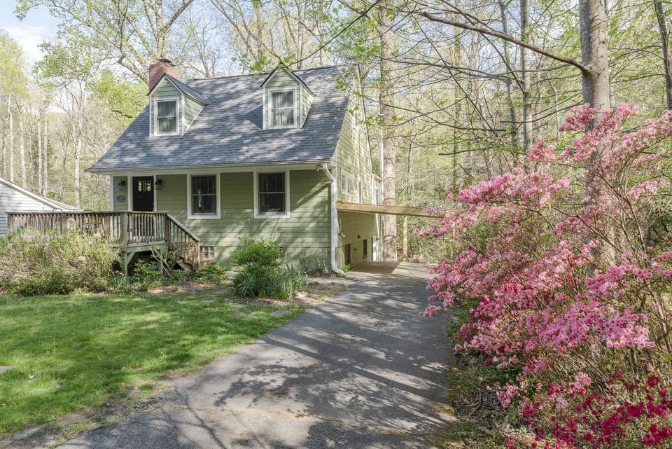 An exterior shot of Flat Creek Cottage, showcasing its charming architecture and integration with the natural landscape.