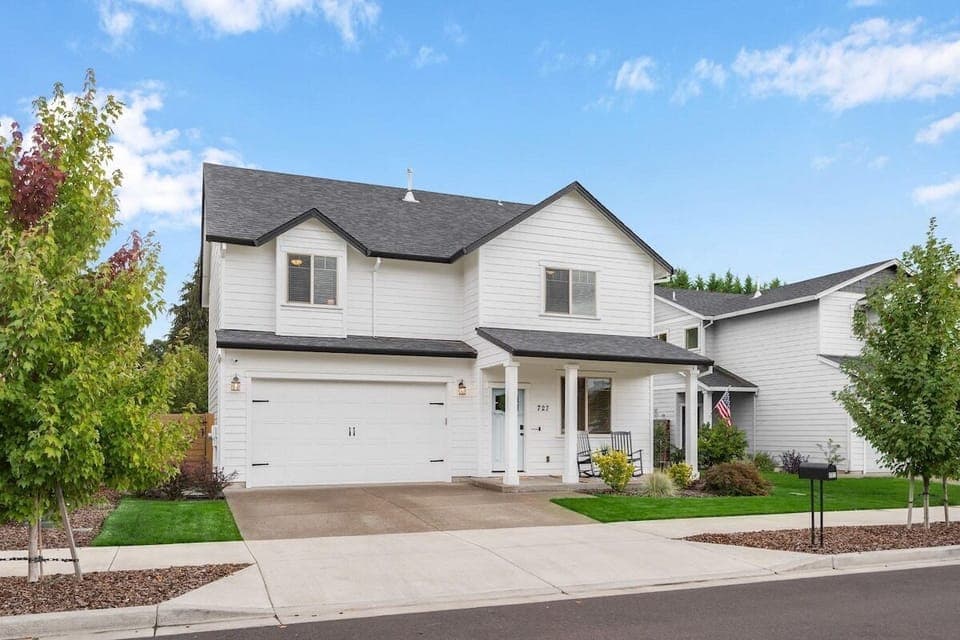 The welcoming front of the house with two rockers on the porch looking at a park and wineries. The sea-foam door welcomes you into your wine getaway weekend!