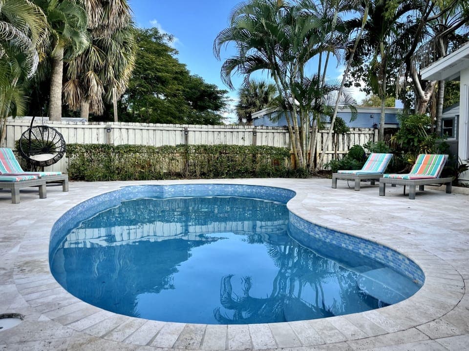 Heated private pool with 4 lounge chairs and a swing chair